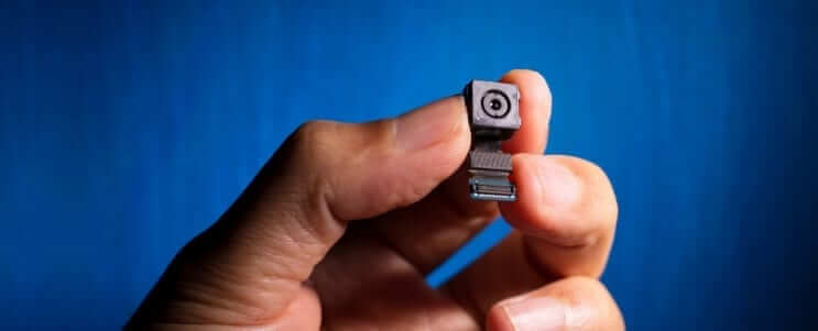 a hand holding a mini camera lens