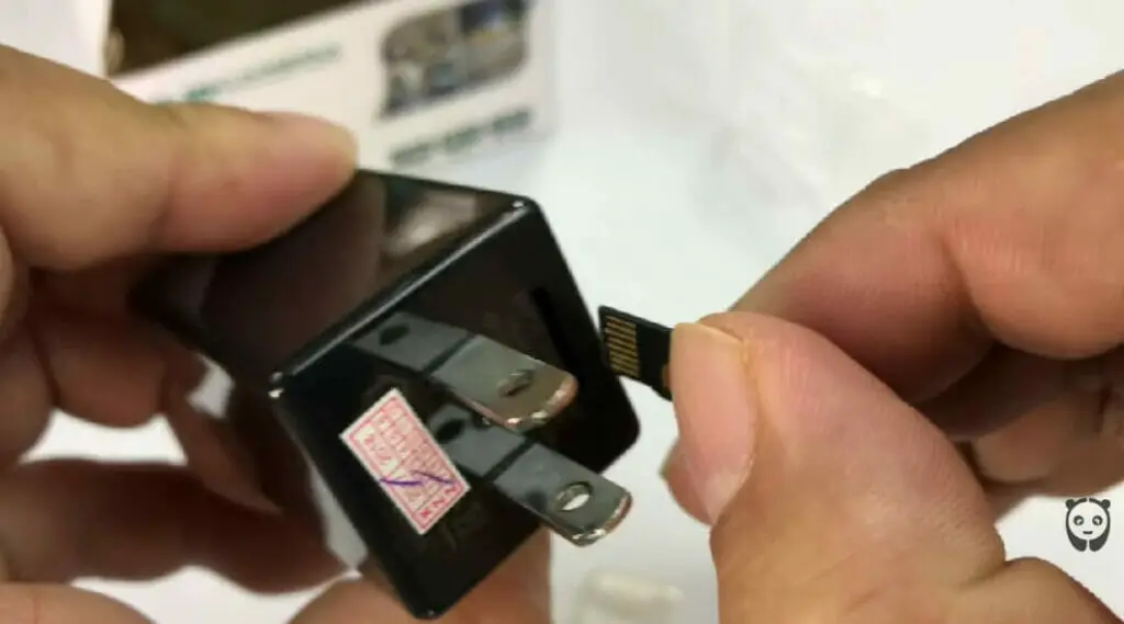 a hands holding and inserting the micro-sd to a spy camera