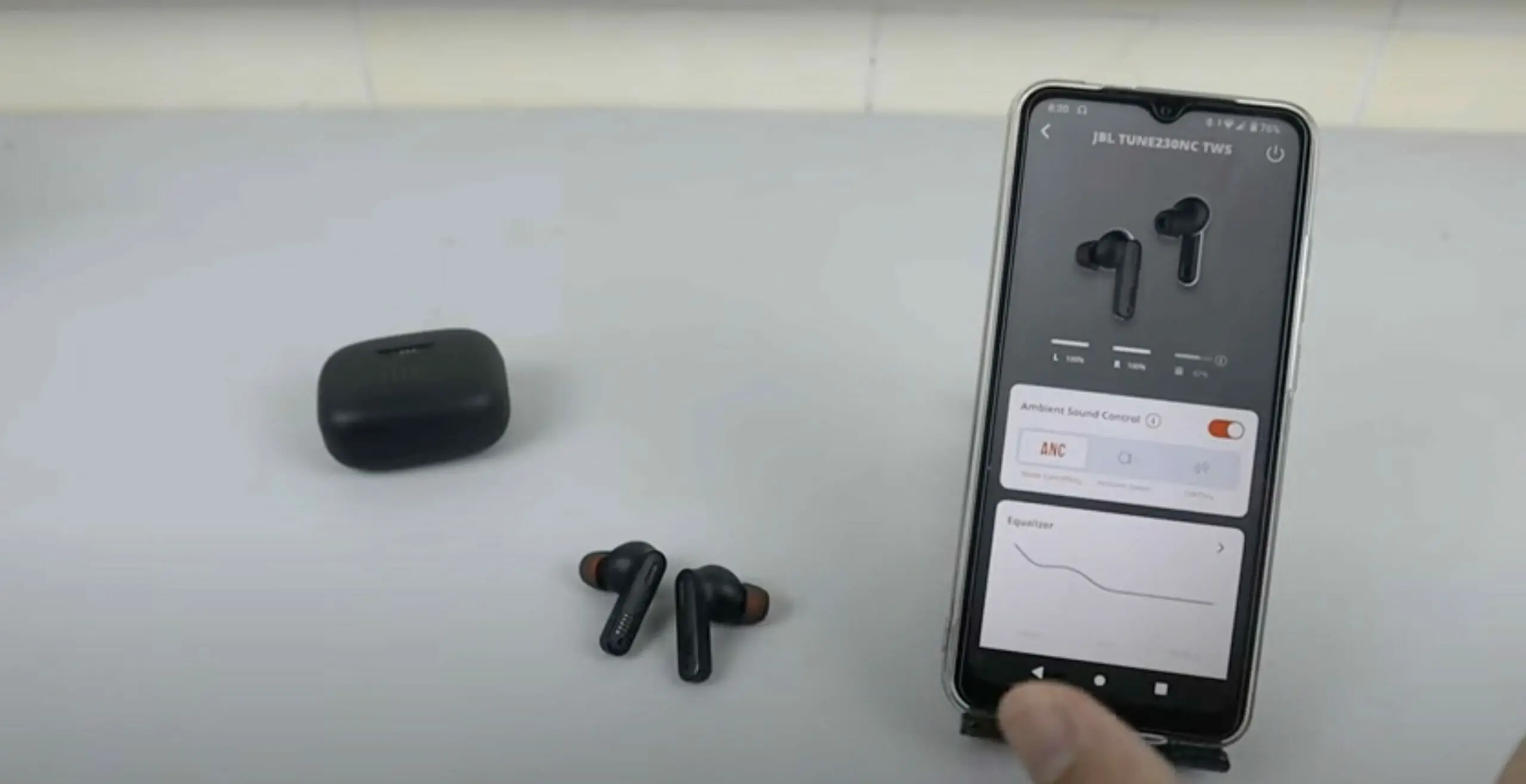 JBL earbuds besides a phone