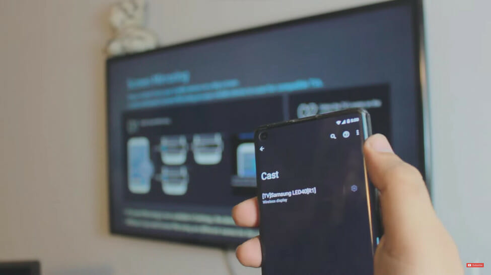 a hand holding a phone trying to screen mirroring the tv and mobile phone