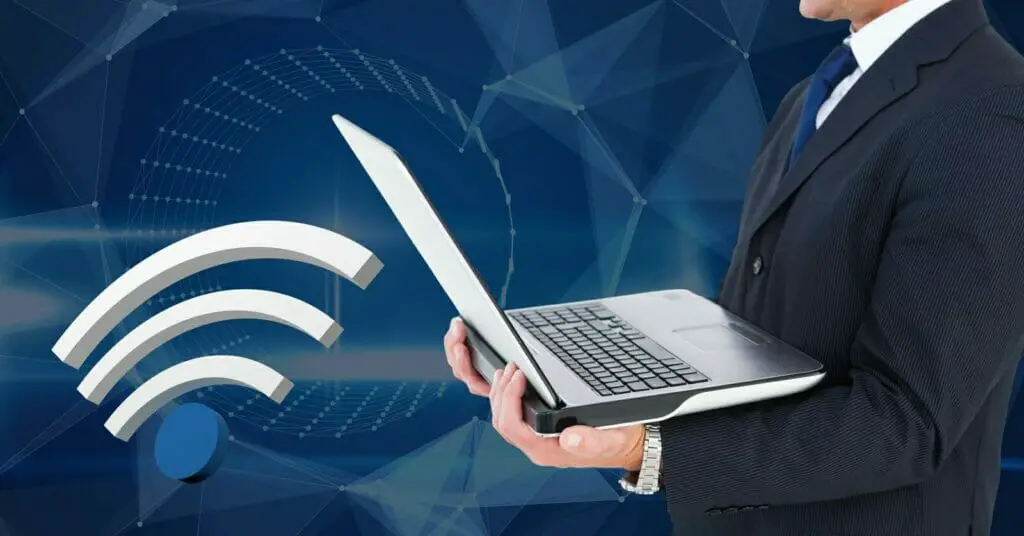 a man in a business suit holding a laptop with a wifi graphic icon