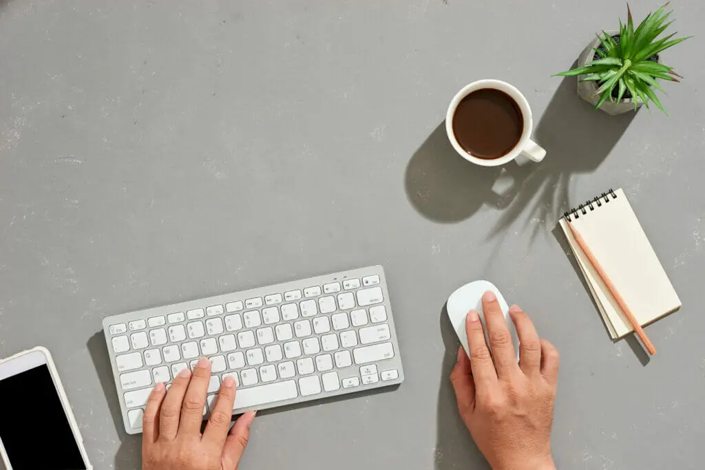 a top shot of a hands working with wireless keyboard and wireless mouse