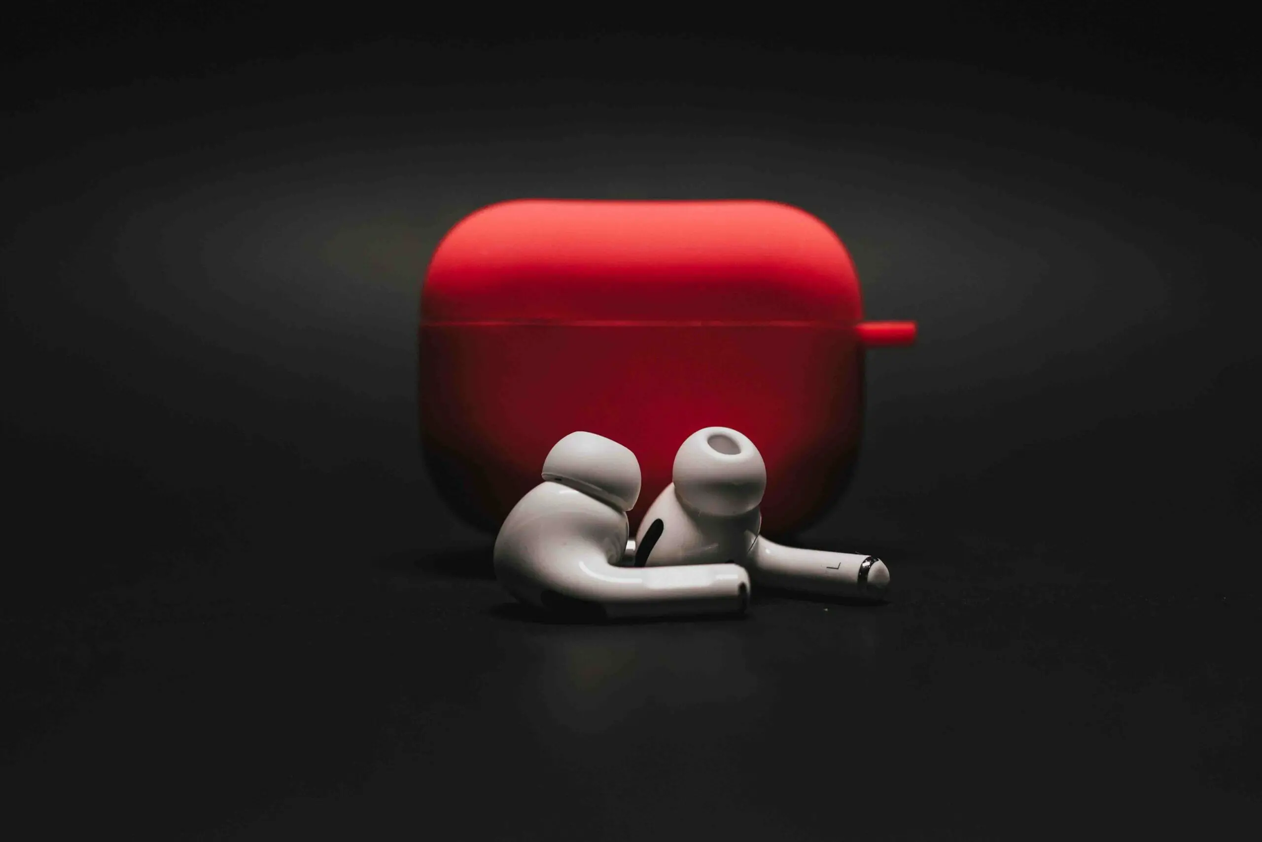 an earbuds with a red case in a dark background