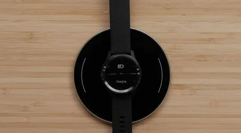 black garmin watch charging using a black wireless charger
