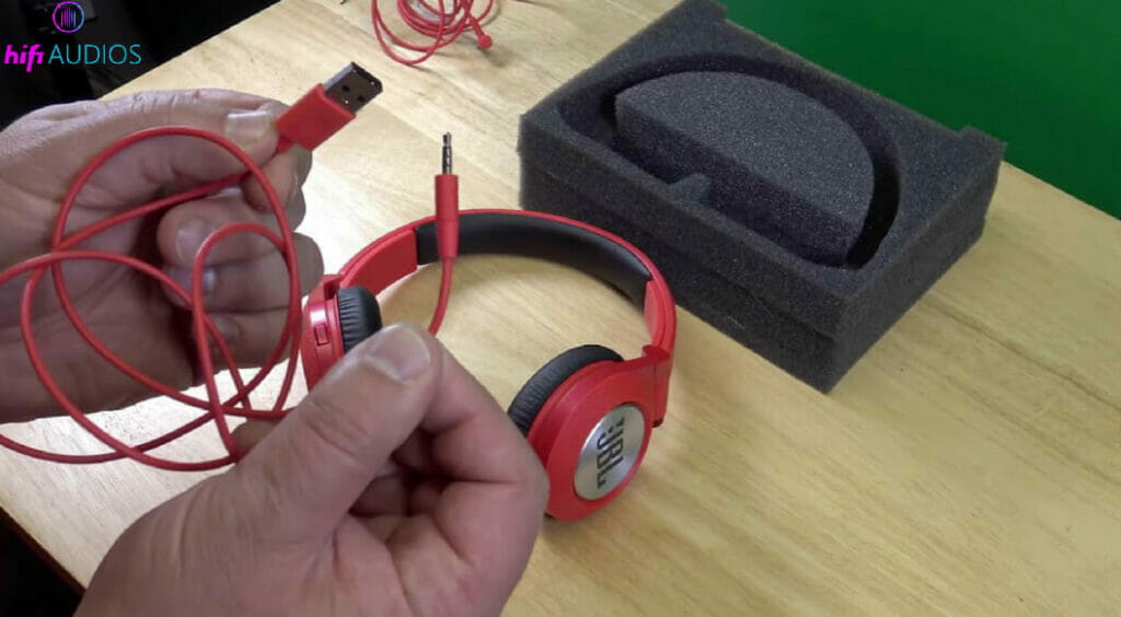 hands holding the charging wire of a headphone