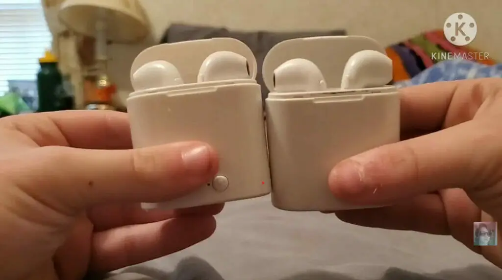 hands holding two sets of earbuds