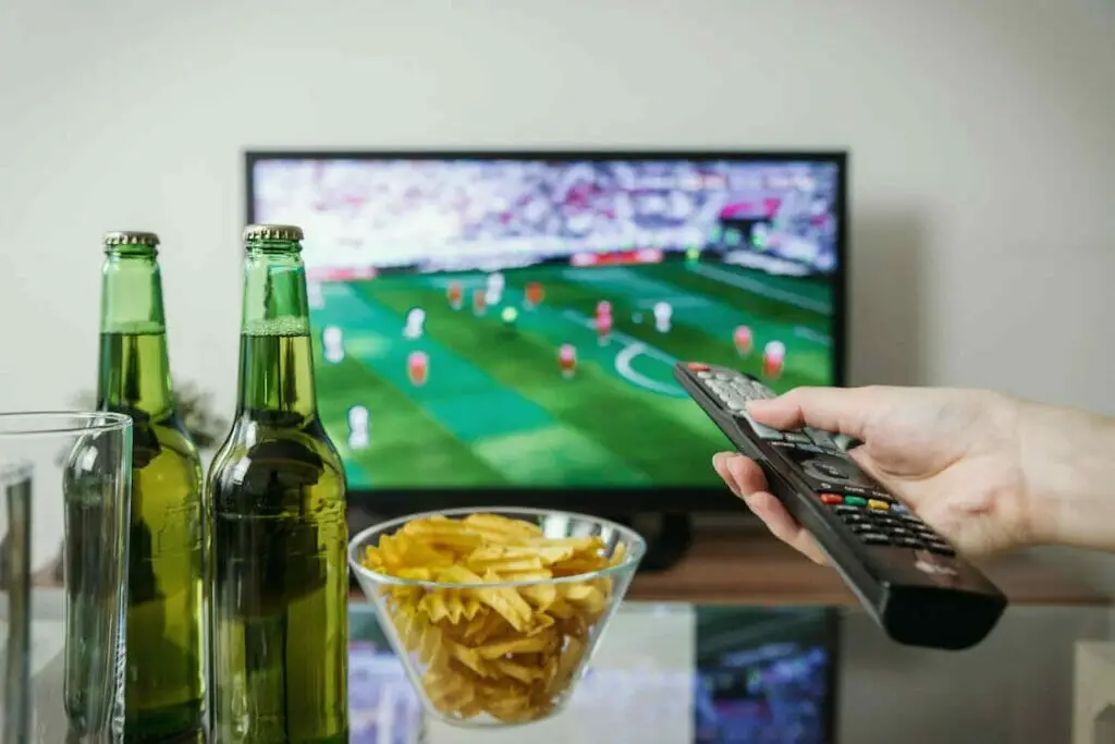 man changing the channel on his tv using a remote control