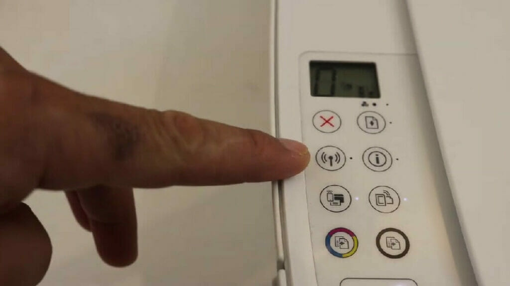 man pointing at the wireless radio button on HP printer