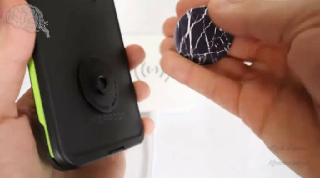 man putting a popsocket at the back of his smartphone