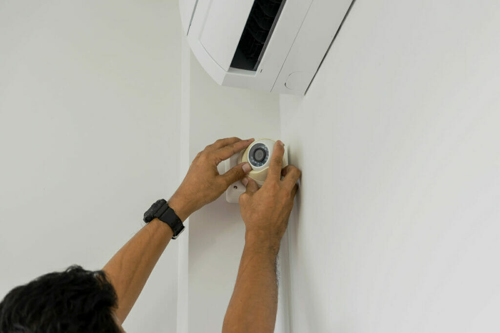 technician installing a security camera at home