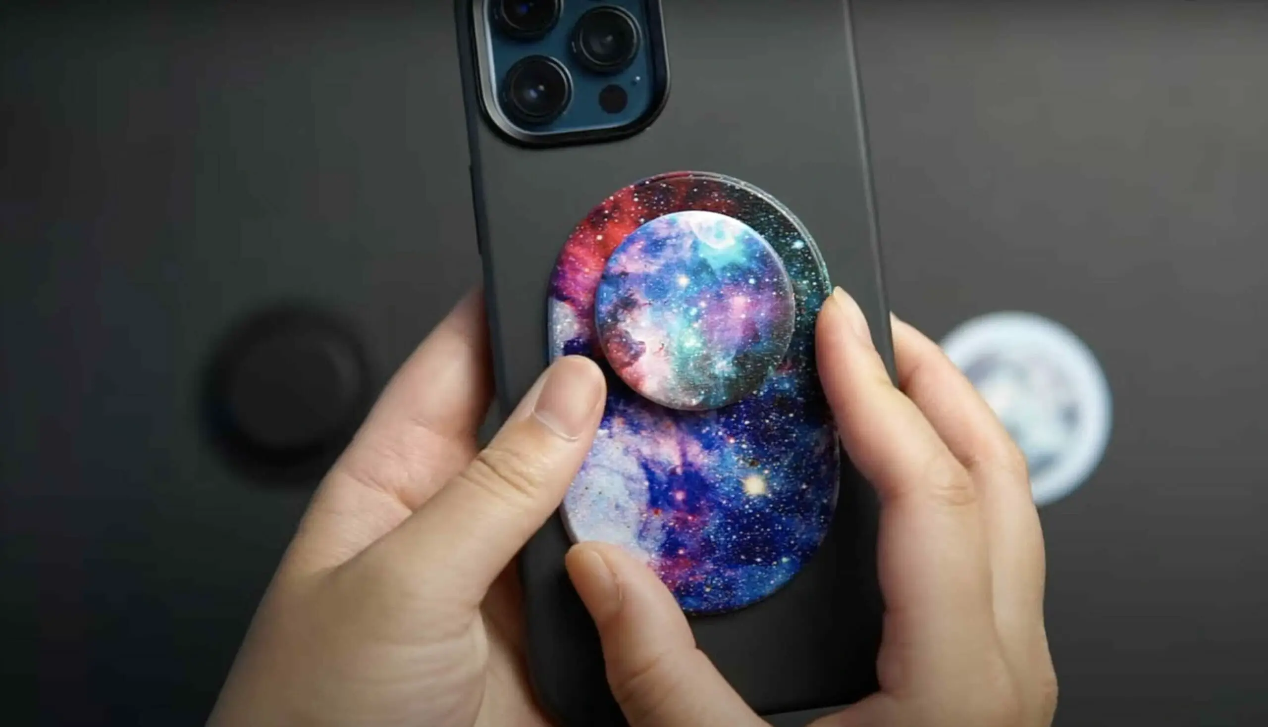 zoom shot of a woman's hand holding a phone with popsocket