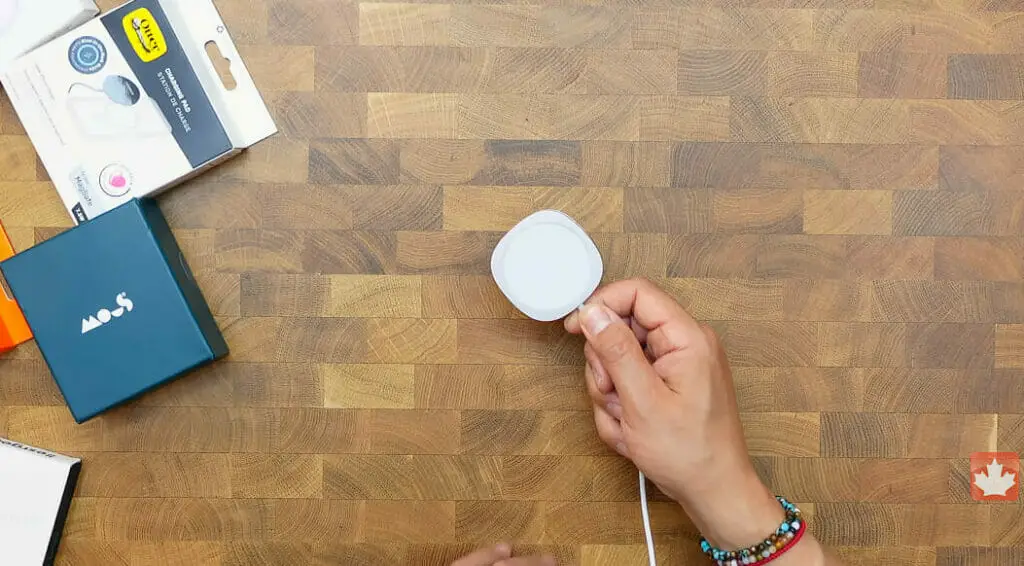 a hand holding a MagSafe Charger