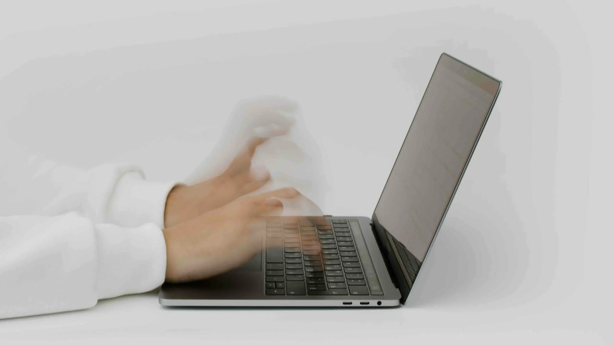 a hand typing on a laptop