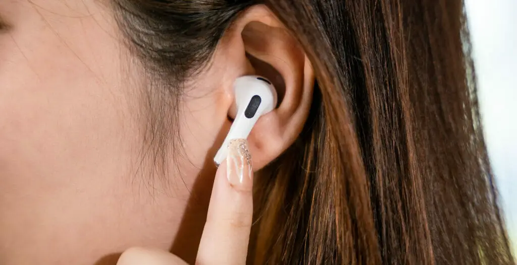 A woman's ear with an earbud