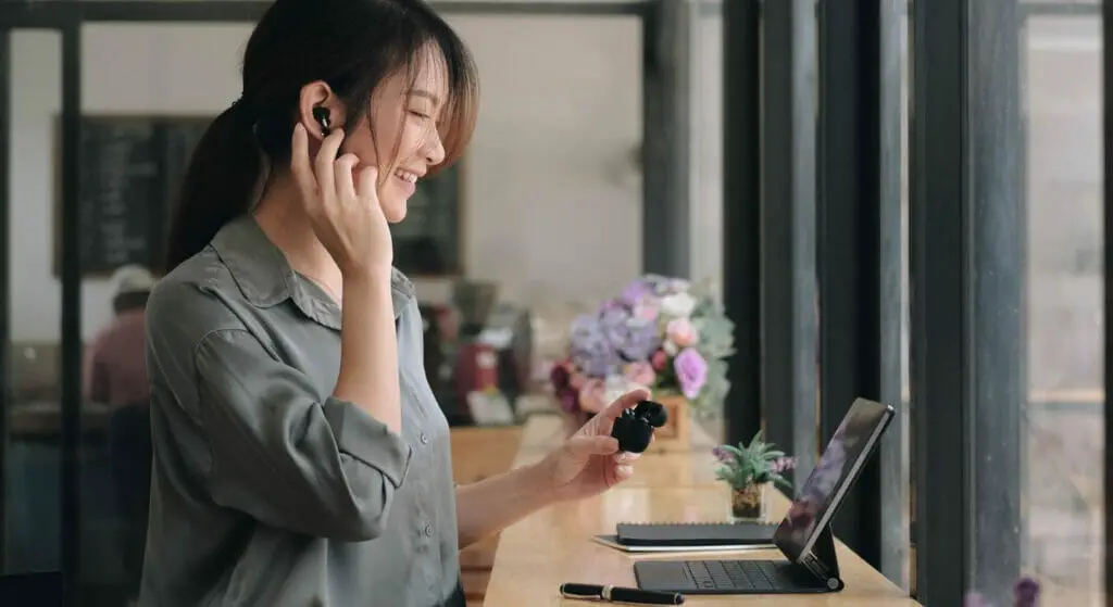 A woman smiling while on video conferencing at a coffee shop