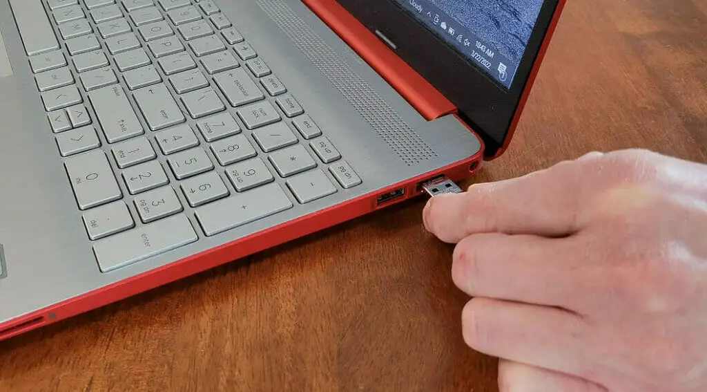 man inserting the USB receiver into the laptop's USB port