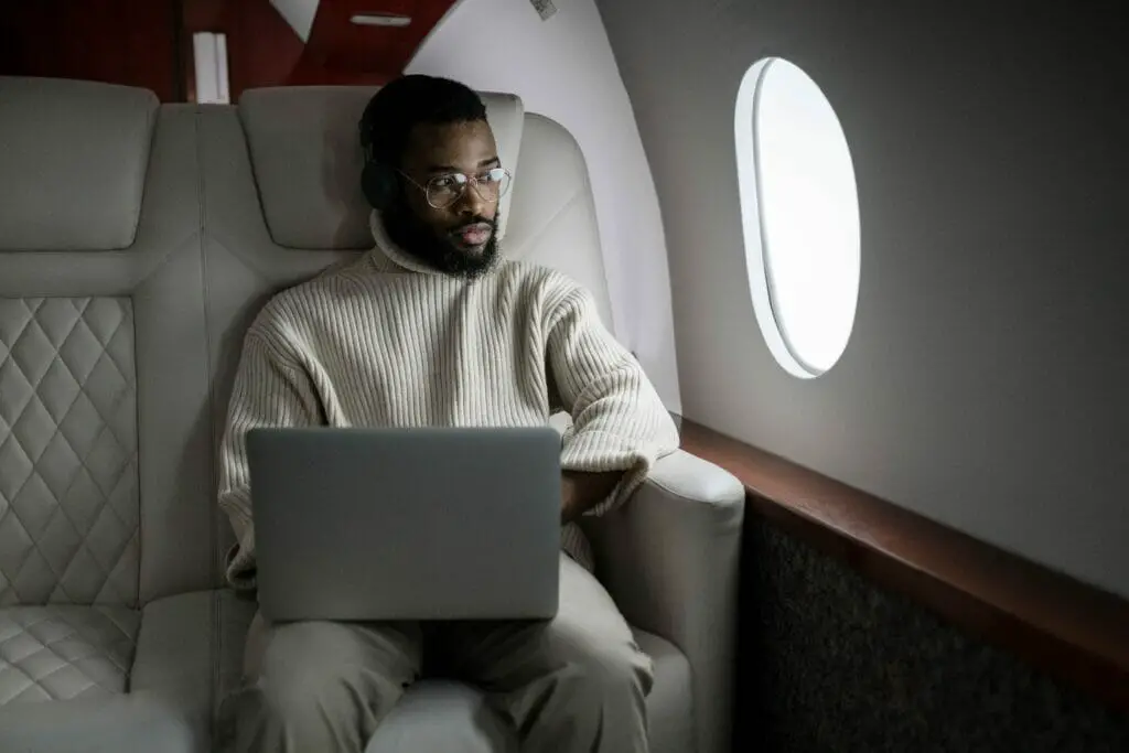 man working with his laptop inside the plane