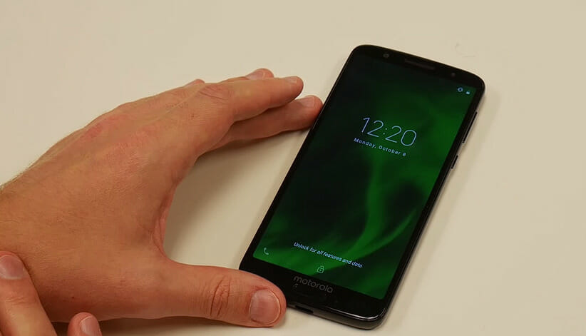 man's left hand touching a phone