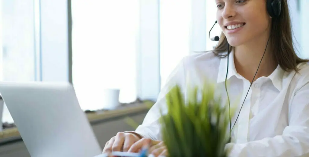 woman on her headphone while working on her laptop