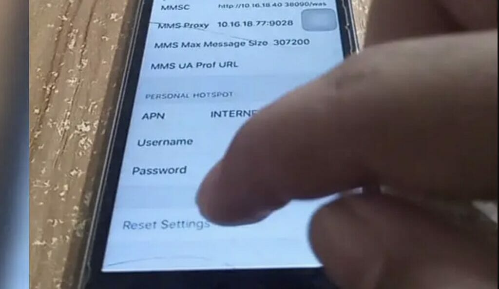 A person tapping the Reset Settings for APN