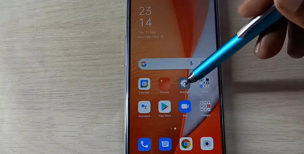 a digital pen points at the setting icon of a phone