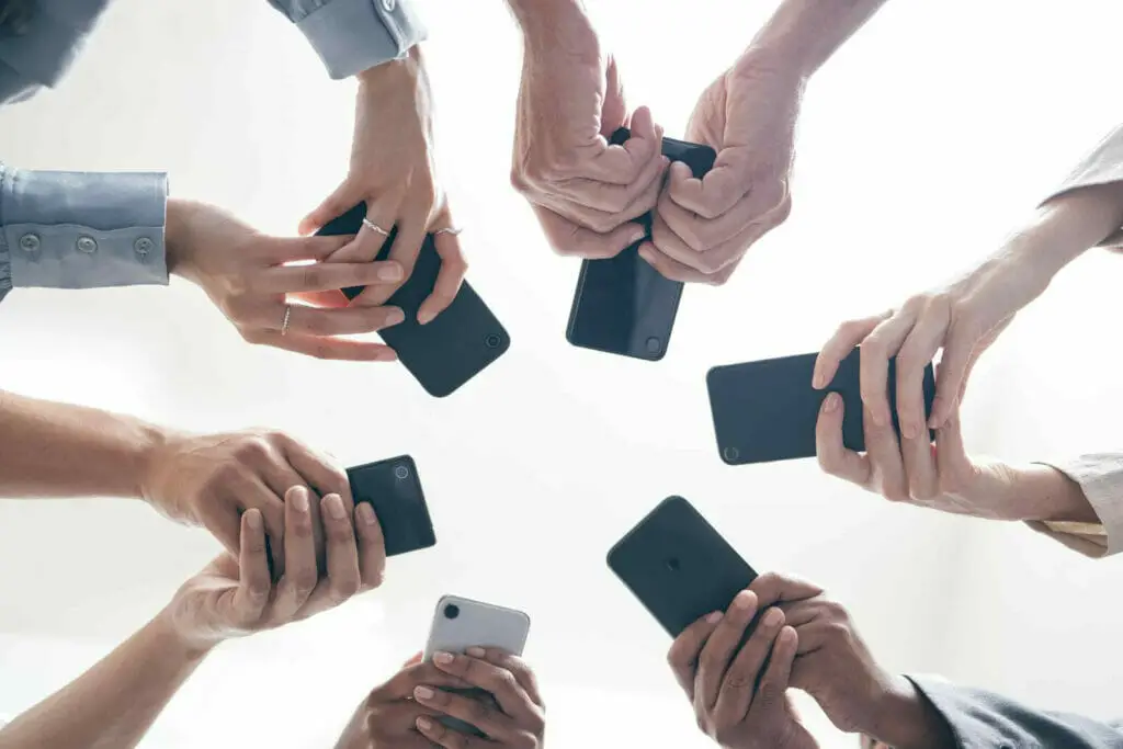 A group of people holding cell phones in a circle