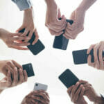 A group of people holding cell phones in a circle