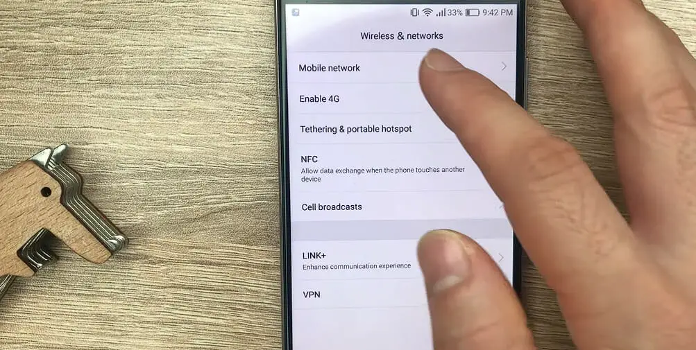 A hand is pointing at Mobile networks on a samsung phone's setting