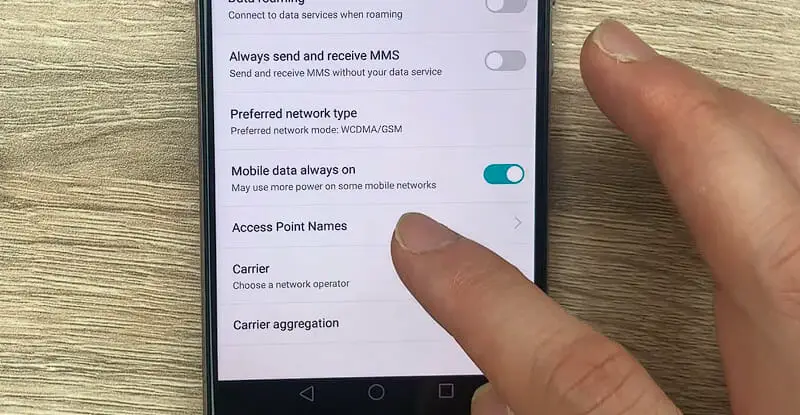 a hand tapping the Access Point Name under APNs phone setting option
