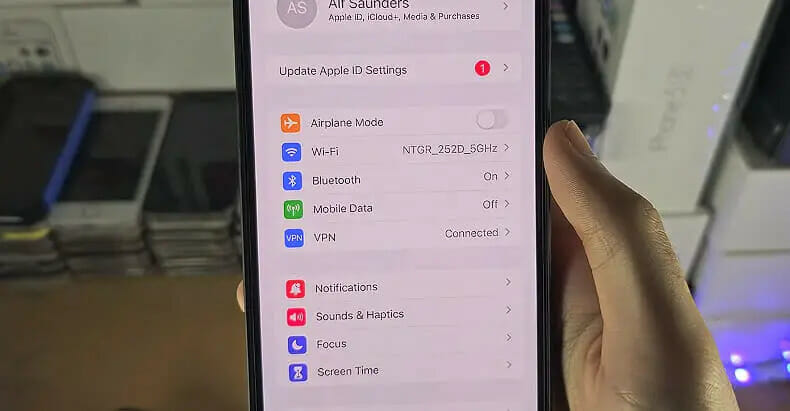 A person is holding up an iphone that shows All Setting options