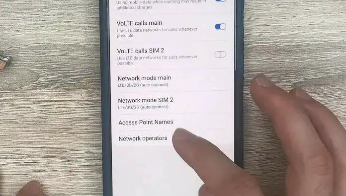 a person's finger tapping the Access Point Names option on the phone setting