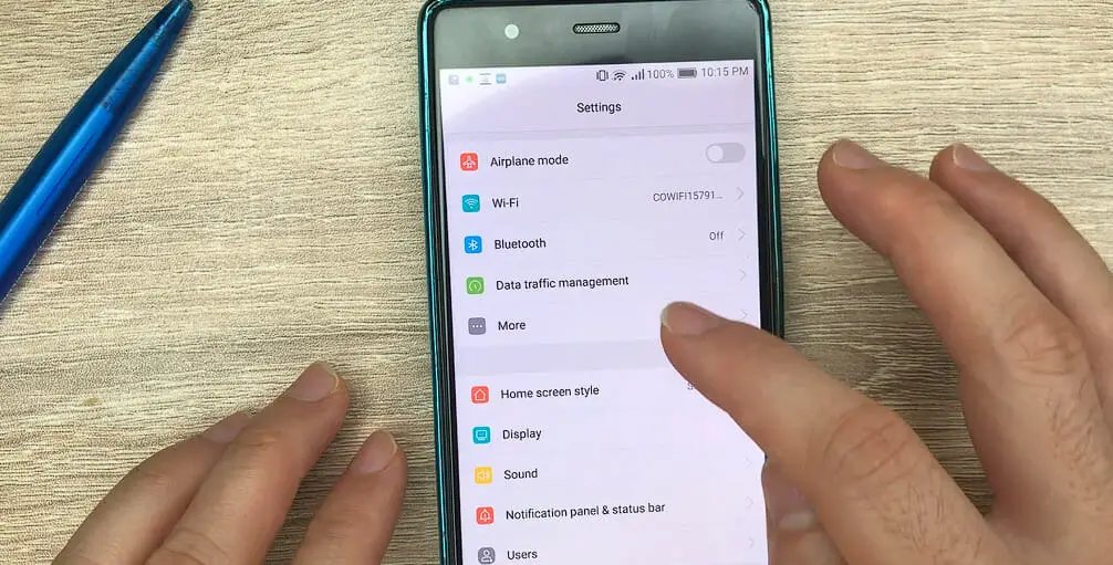 a pointer finger tapping the More option on the setting of a phone