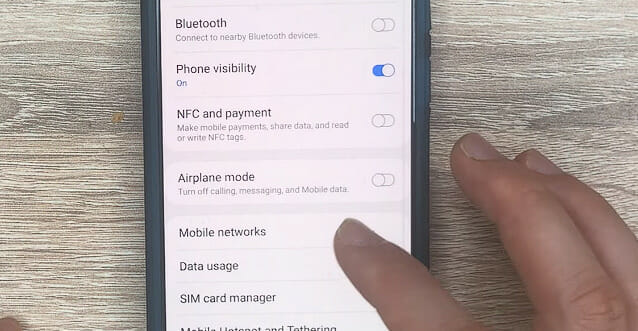 finger tapping on Mobile networks on a phone setting menu