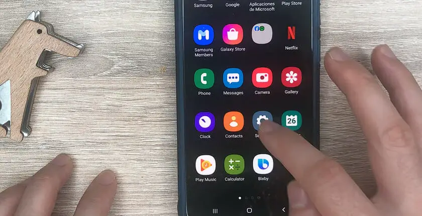 hand tapping the setting icon of a samsung phone