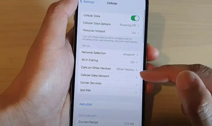 a person tapping on the iphone's Cellular Data Network setting