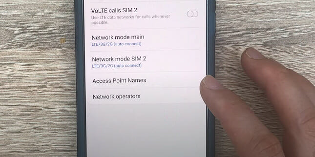 a person tapping on the phone's Access Point Name setting