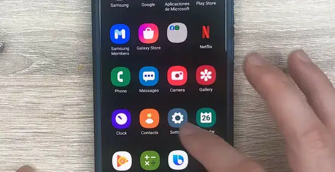 a person tapping on the phone's setting icon