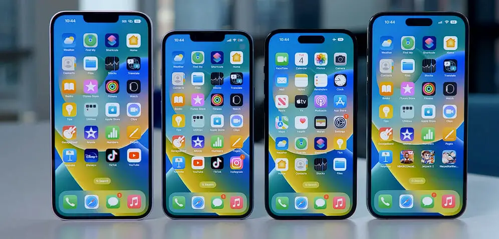 Four different iPhone variations are sitting on a table next to each other
