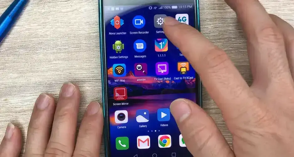 A person holding up an iphone with a lot of icons on it.