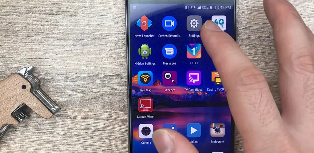 man pointing at the setting icon of a Samsung galaxy s7 edge phone