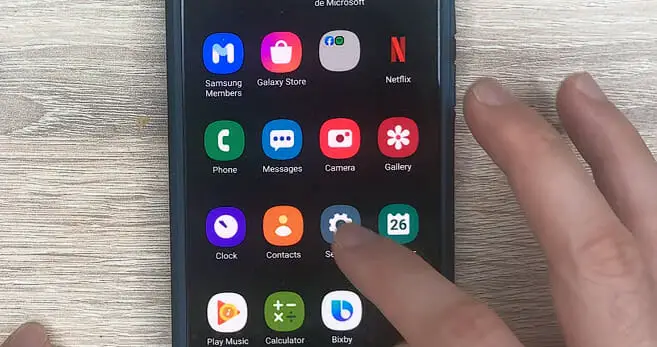 man tapping the setting icon on the phone
