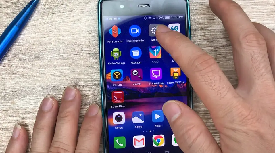 man's hand tapping the setting icon on the homescreen of a phone