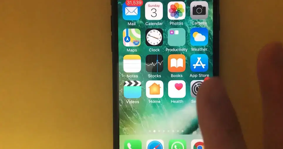 pointer finger tapping on the setting icon from the home screen of an iphone