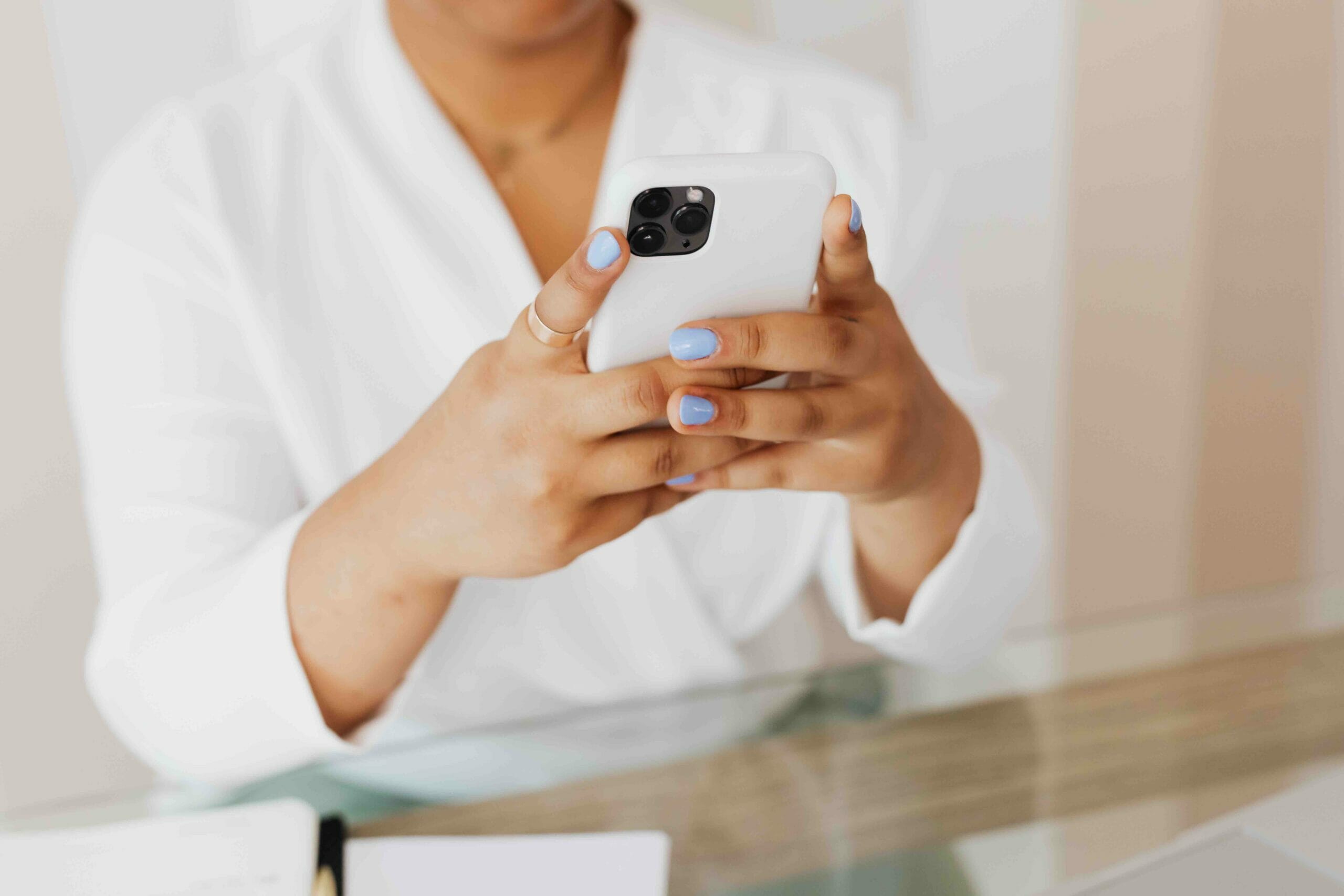 A woman sitting at the conference room holding her white phone