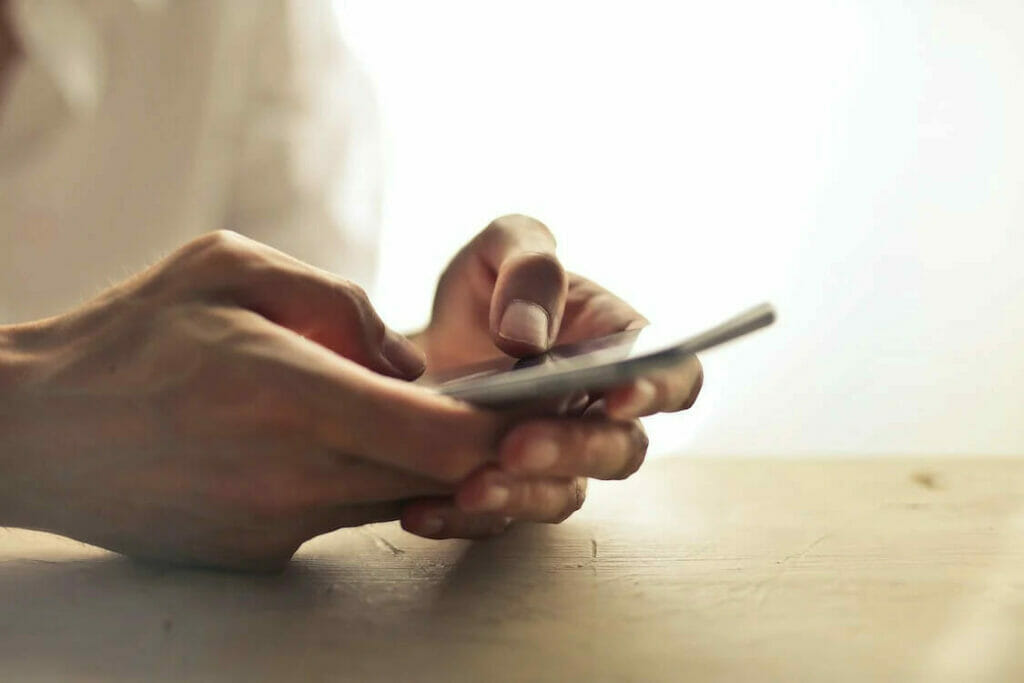 A person is using a cell phone on a table