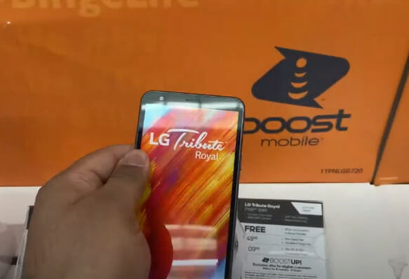A person is holding up a phone in front of an orange box