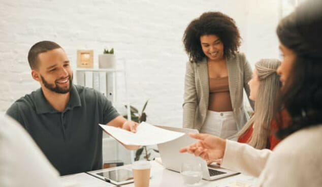 A group of people sitting around a table in an office