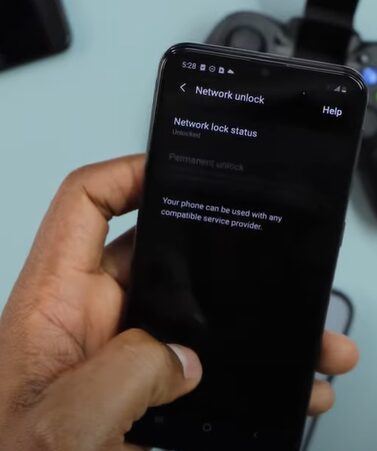 A person holding a phone a navigating to the Network unlock setting