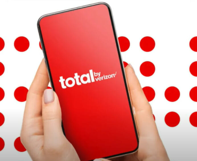 A woman holding a phone with total by verizon logo on it