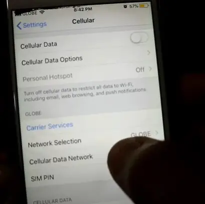 A person is holding an iphone and navigating to Cellular Data Network setting